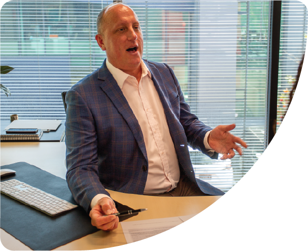 A professional business man in a suit at his office desk having a discussion with someone