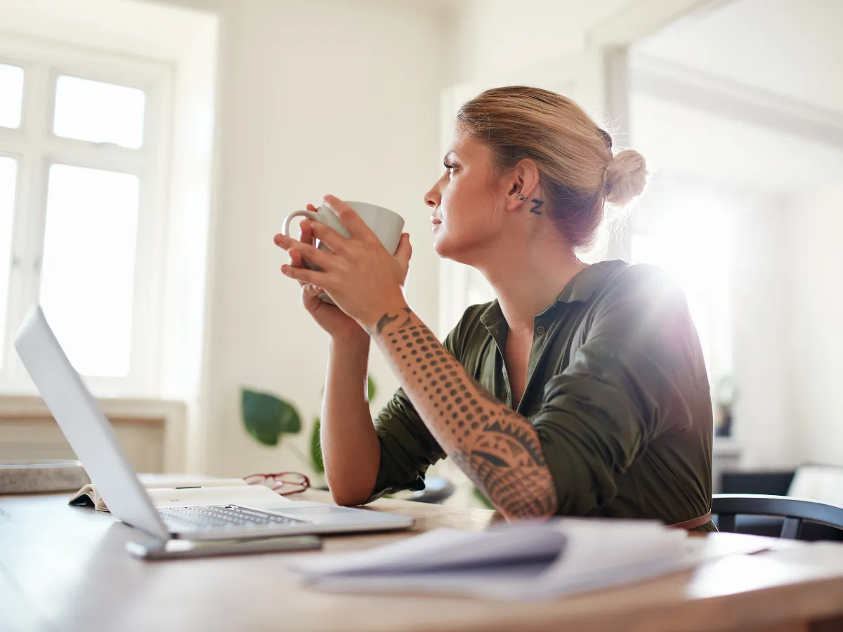 woman holding coffee looking out the window