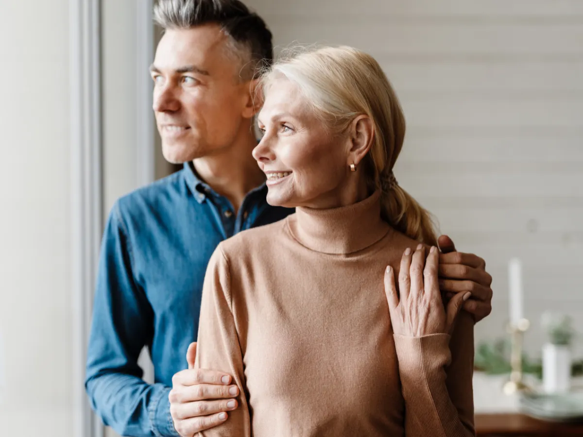 man and woman looking outside the window