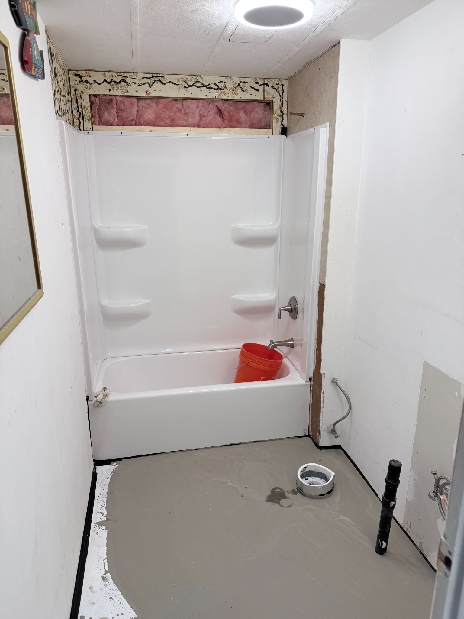 New tub and shower surround with floor leveler in progress