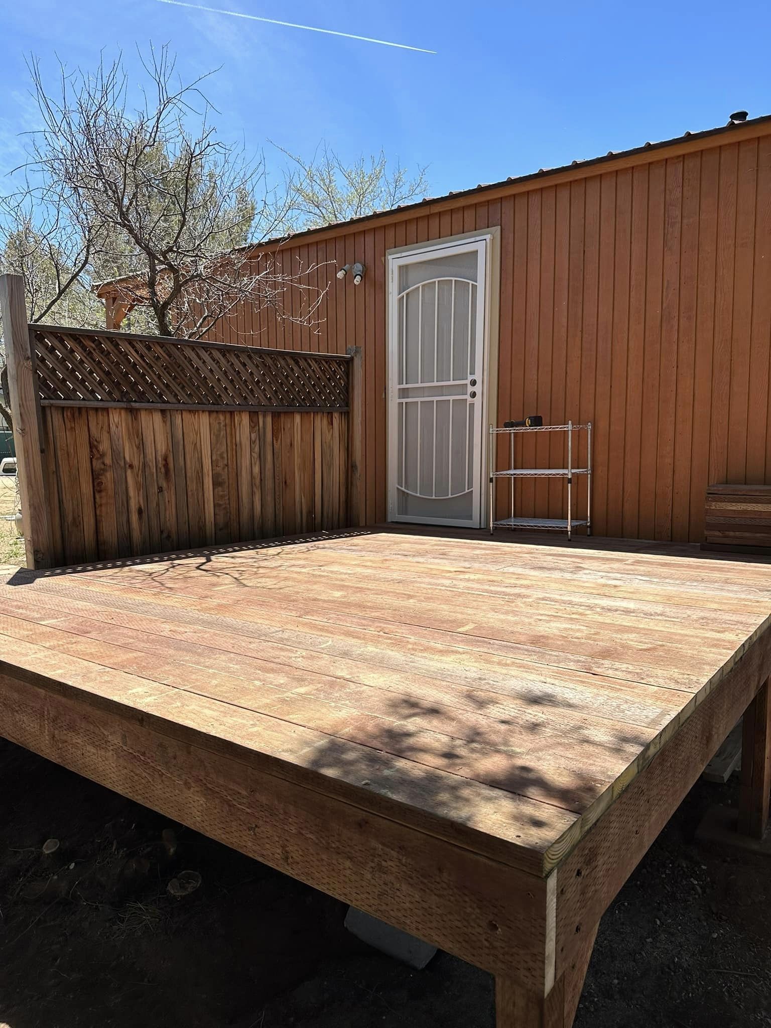 Completed open wood deck beside a cabin