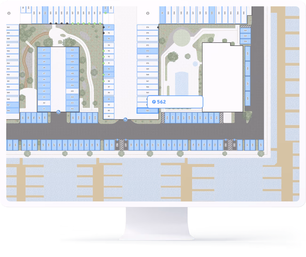 Computer screen displaying a detailed smart parking map for a mixed-use area with labeled parking spaces, two green areas, and pathways, highlighting parking spot 562.