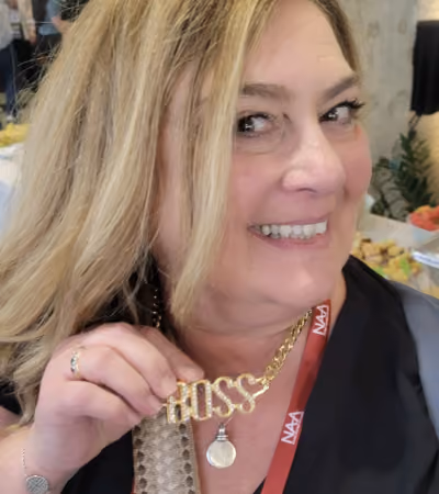 Boss Photo Wall: conference attendee holding up her gold BOSS necklace