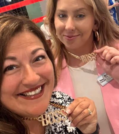 Boss Photo Wall: two property managers showing off their gold BOSS necklaces
