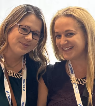Boss Photo Wall: two property managers in BOSS necklaces at a Yardi conference