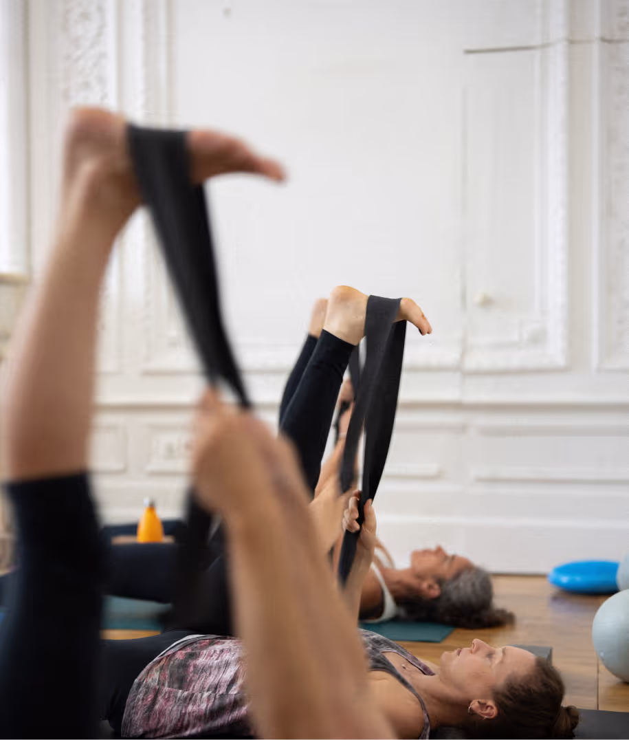 Des pratiquantes de yoga en supta padangusthasana avec une sangle