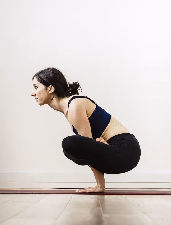 Amélie dans kukkutasana, posture de yoga du coq, en équilibre sur les mains en lotus