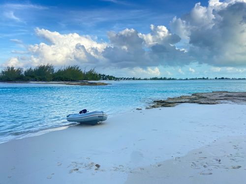 Serene beach setting with a dinghy sitting on the white sand of a bahamiam beach