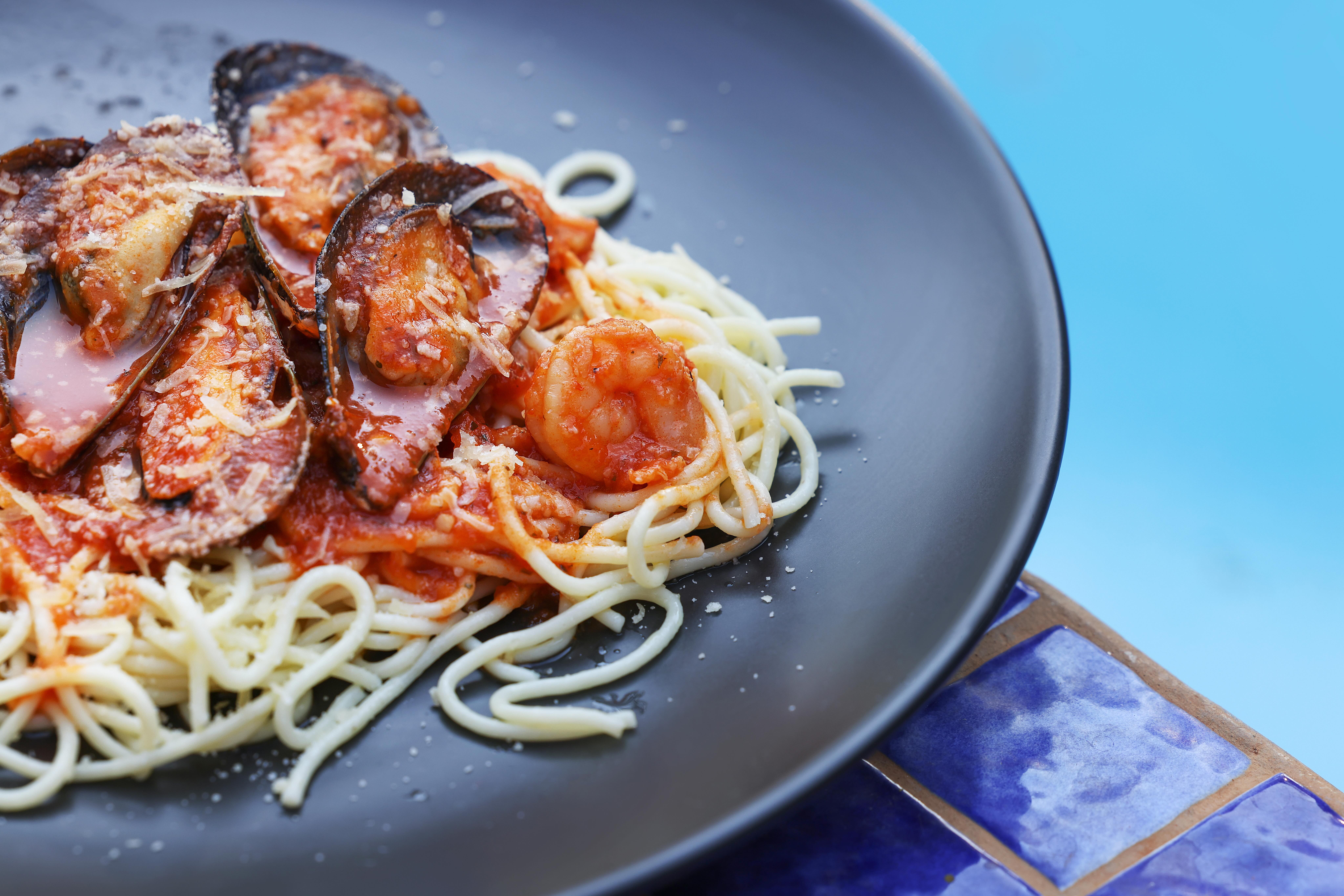 a plate of spaghetti with seafood and sauce
