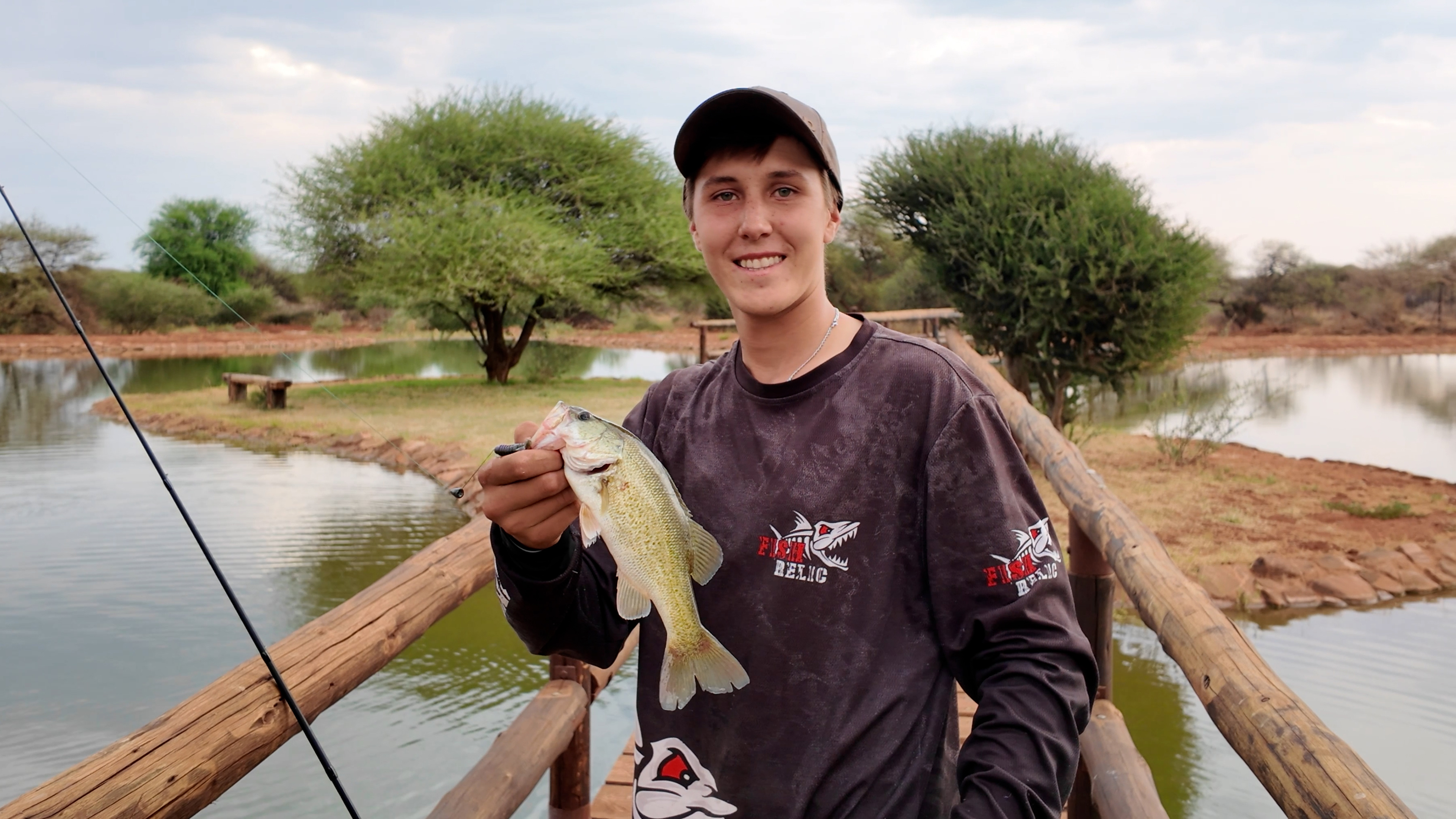 Man holding a bass he caught at Naka luxury Lodge Playing with Pisces Fishing experience