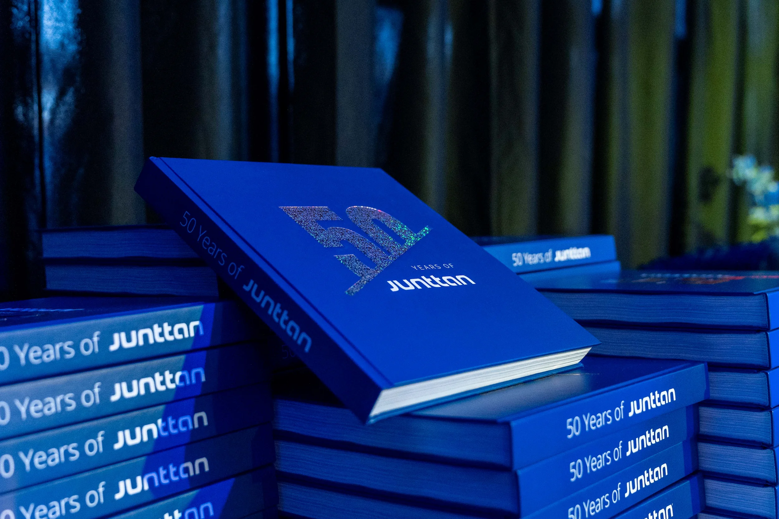 een stapel jubileumboeken '50 years of junttan', klaar om uitgedeeld te worden