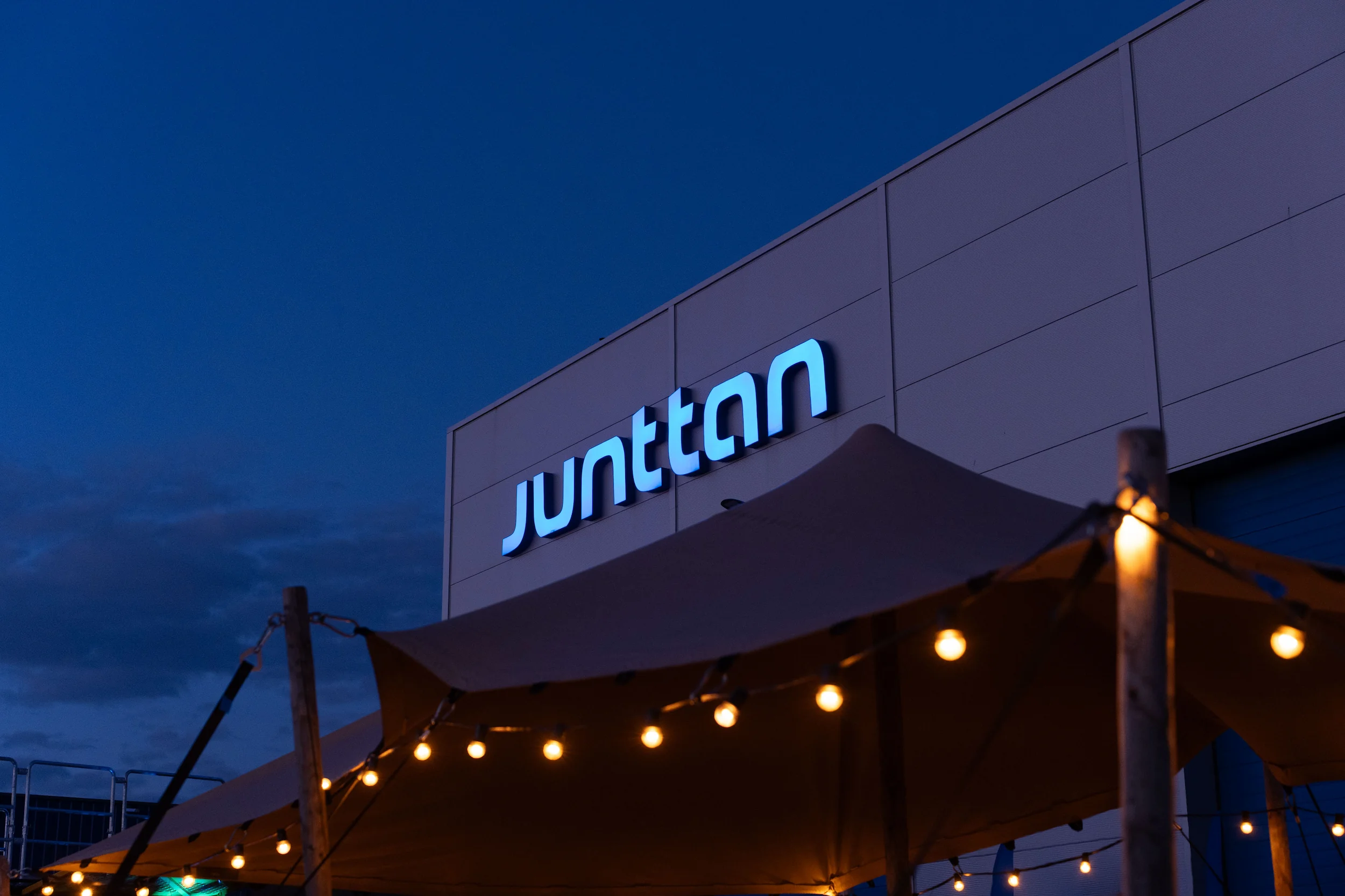 het pand van junttan bij avond, met lichtjes en een feesttent voor de deur