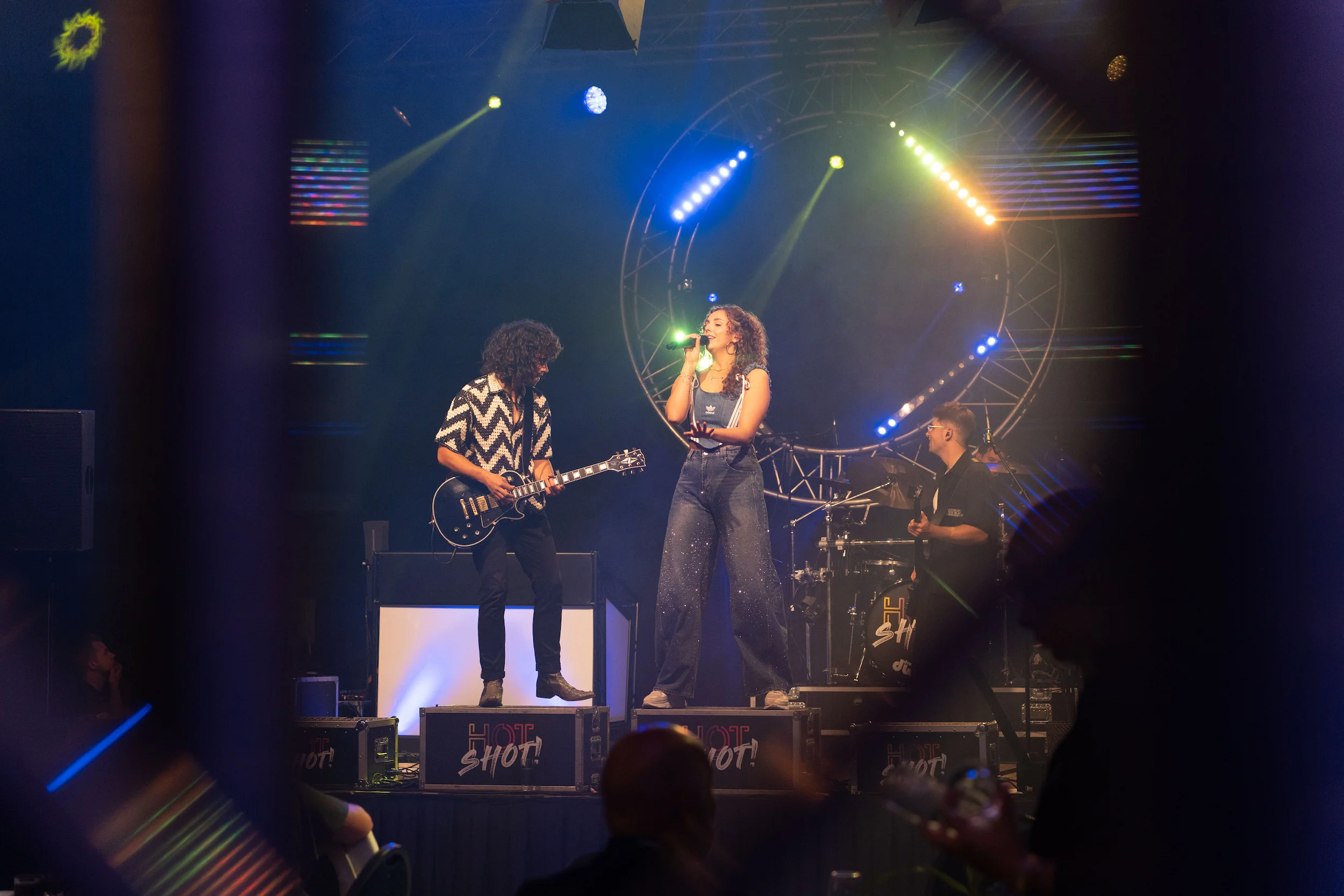 zanger en gitarist samen op het podium, vastgelegd tussen de gasten door
