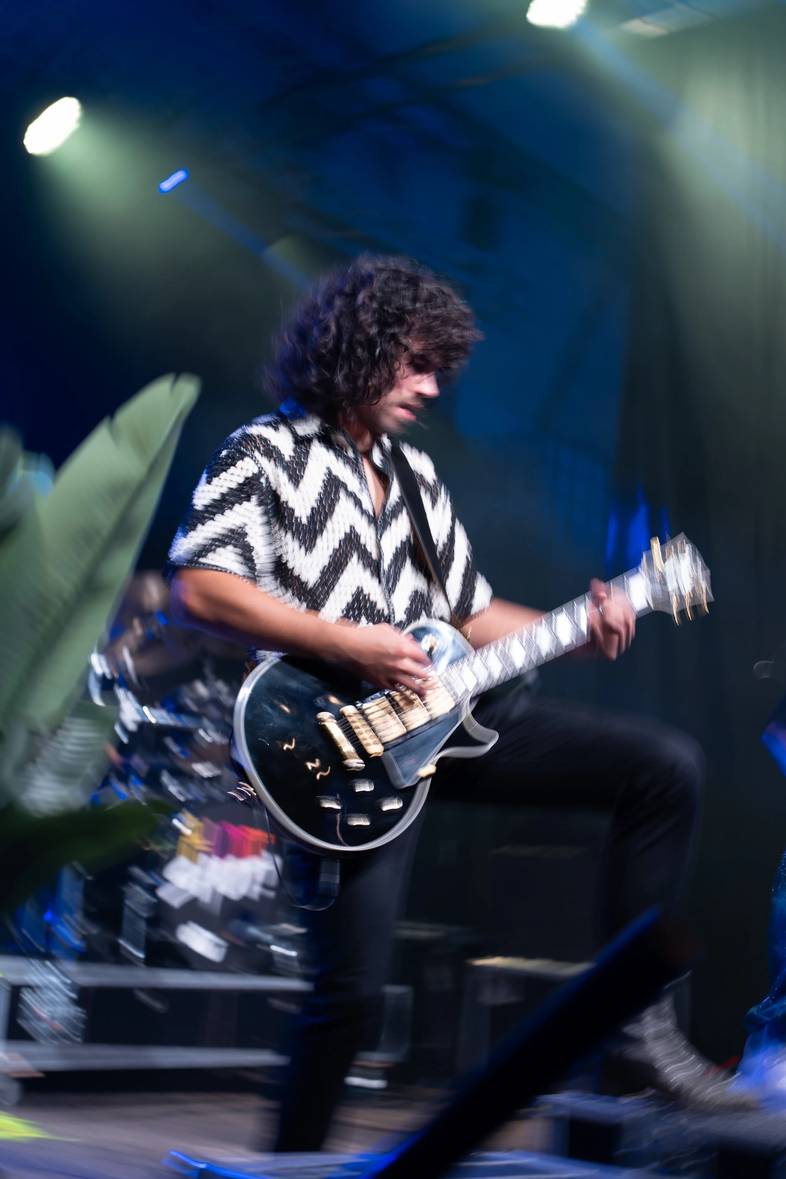 een gitarist in beweging, vastgelegd met een dynamische, wazige belichting