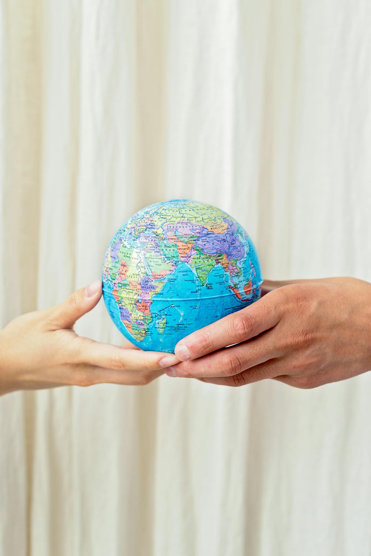 Person holding globe representing multilingual guest communication worldwide