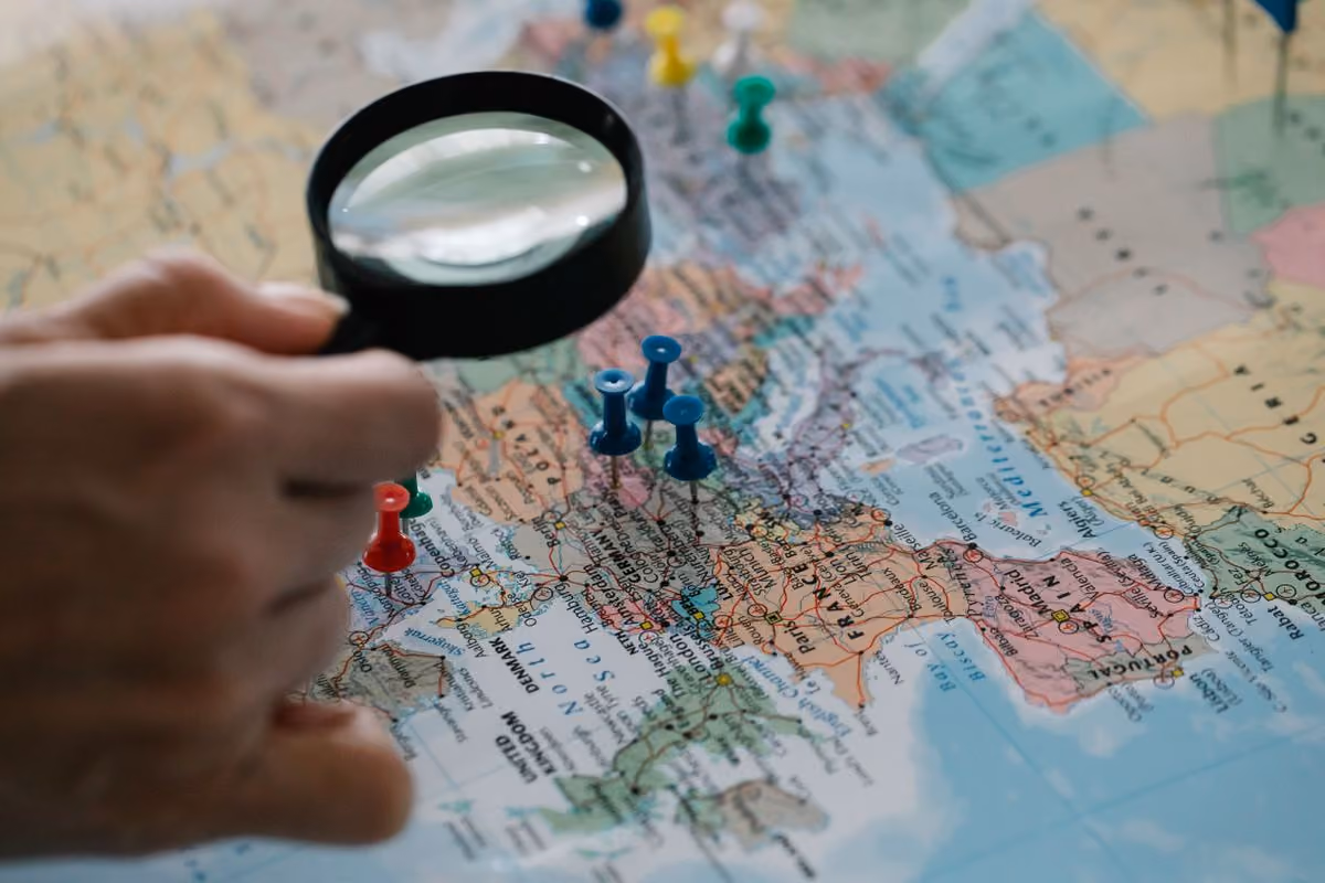Magnifying glass over map pins representing travel search channels