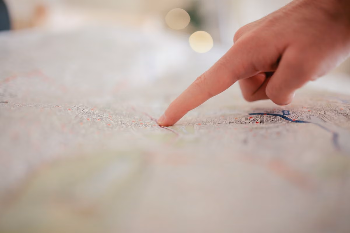 Hand pointing at a city map with destinations highlighted