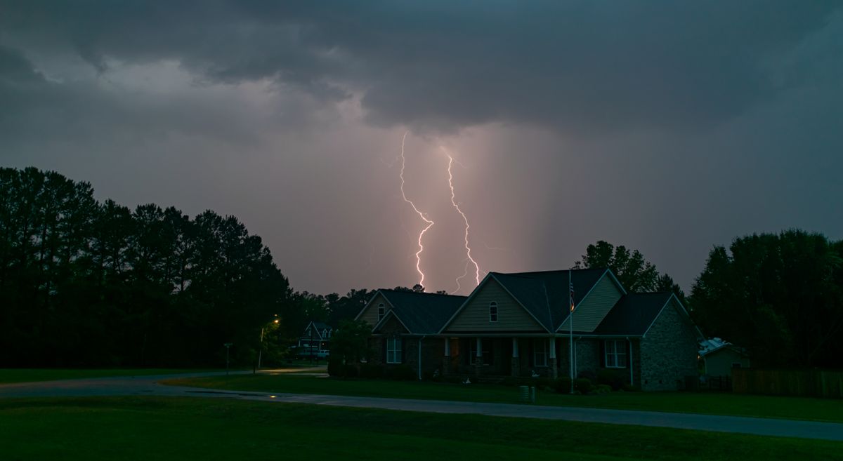 Lightning bolt over a suburban neighborhood during a storm