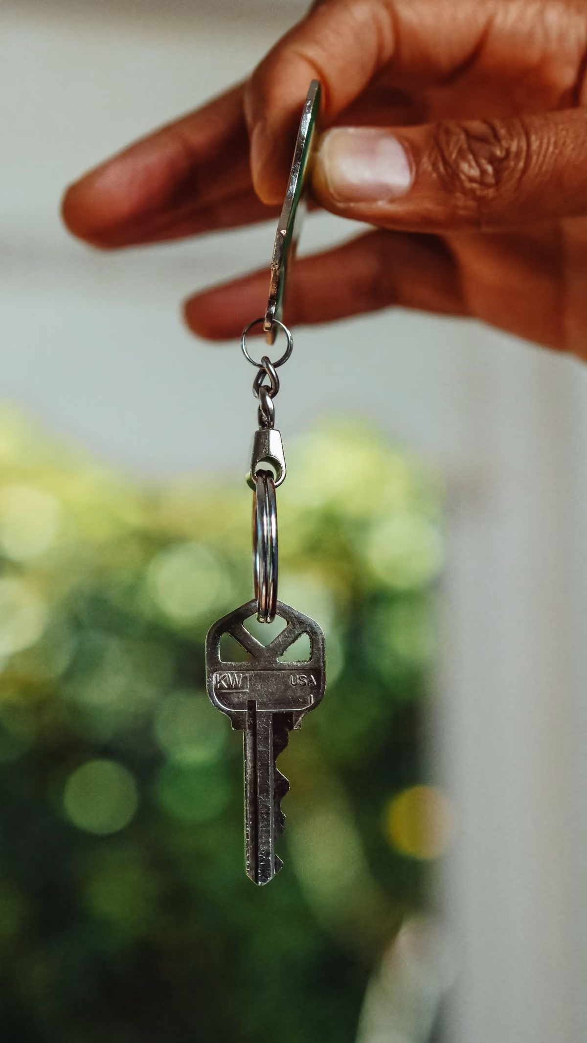 Main tenant une clé de maison symbolisant le départ du logement