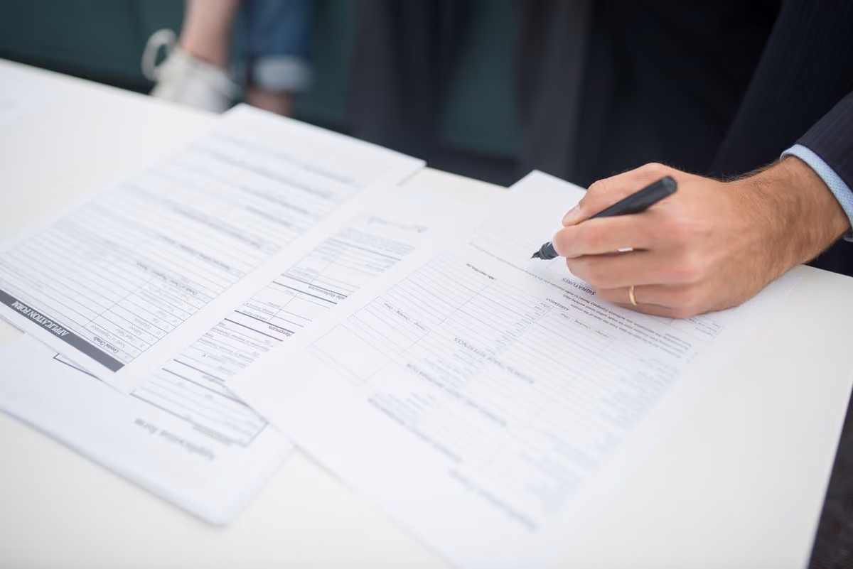Hand signing insurance paperwork protecting a host