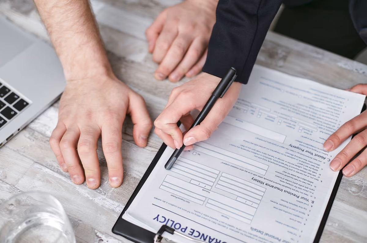 Two people signing a liability insurance document