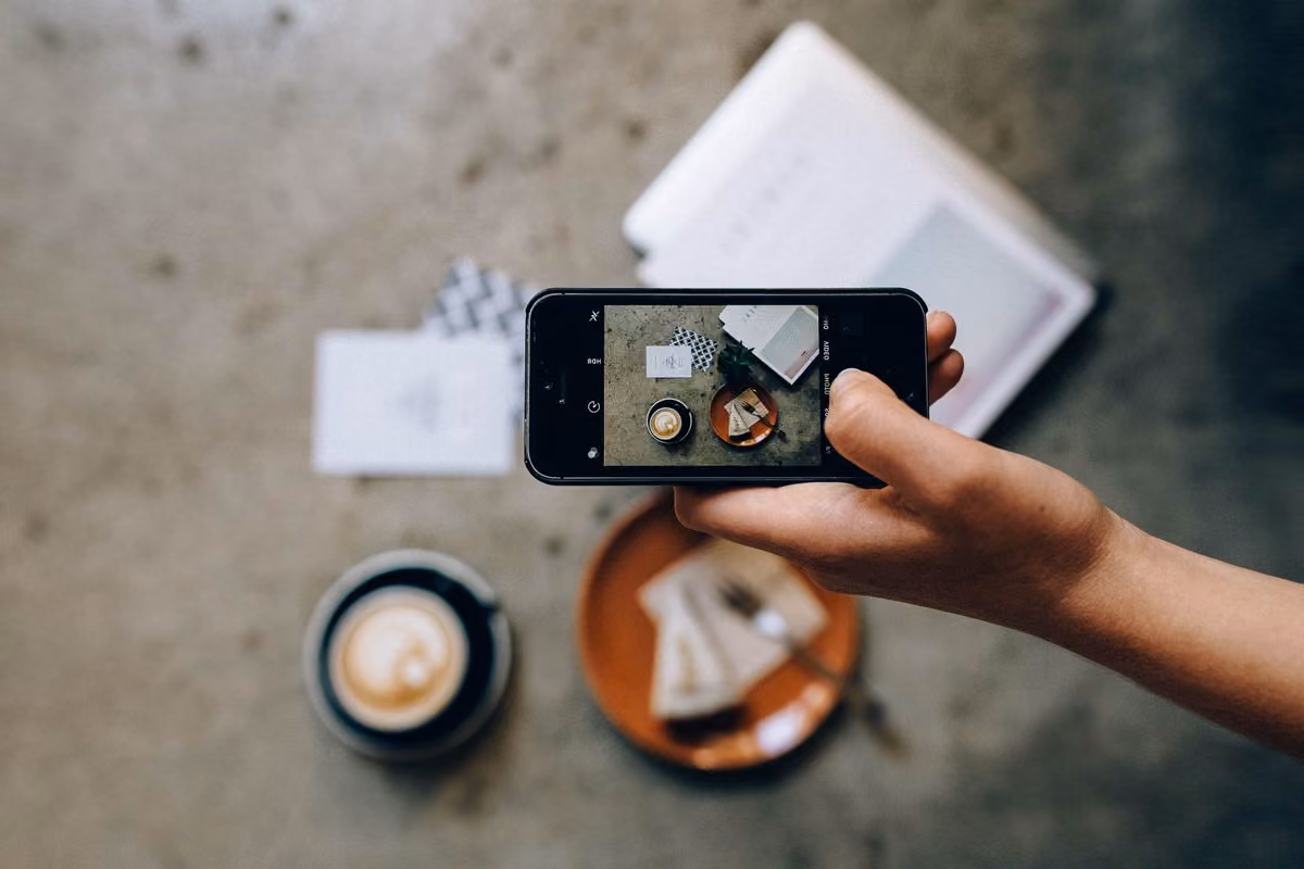 Main prenant une photo avec un smartphone pour les réseaux sociaux