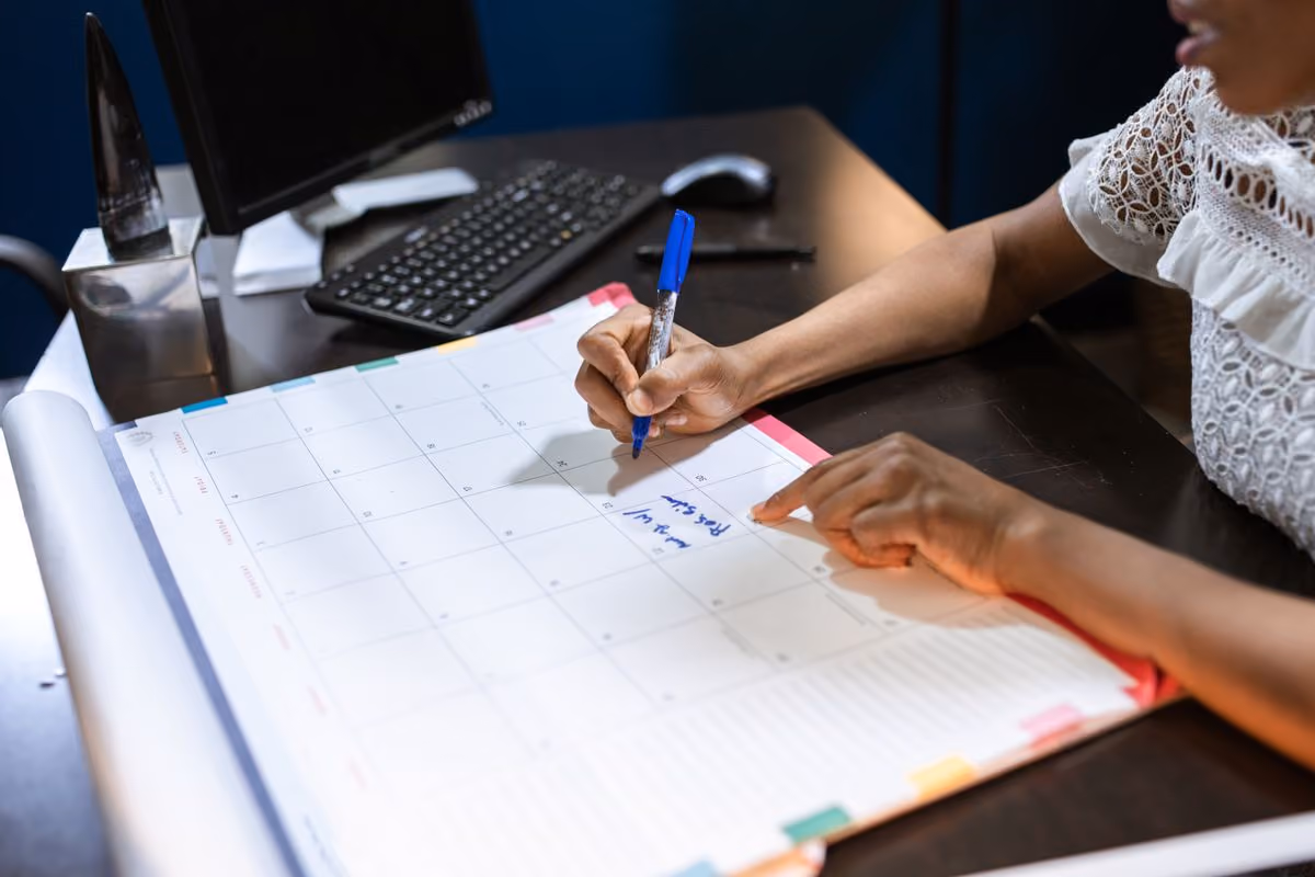 Person planning length-of-stay discounts in a desk calendar
