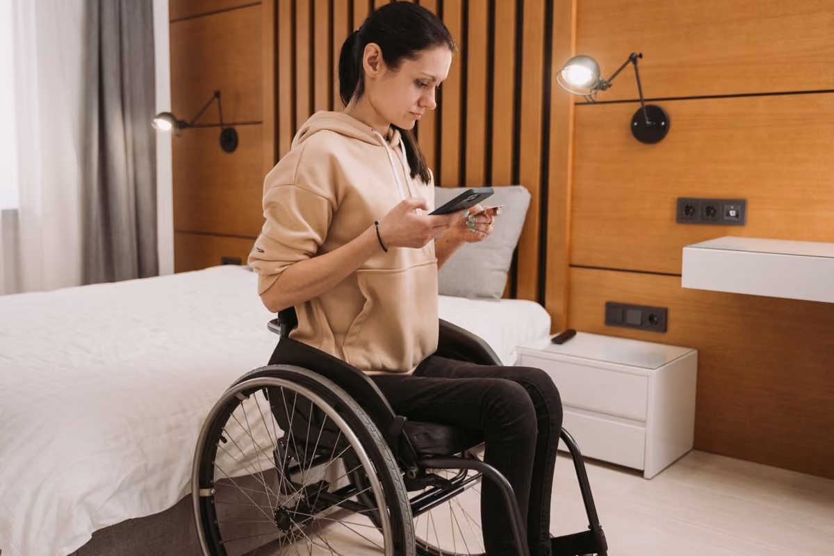 Woman in a wheelchair using a smartphone in an accessible space