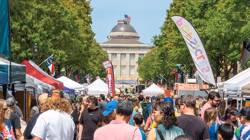 crowd of people in front of stage and state capitol at Cuegrass Festival