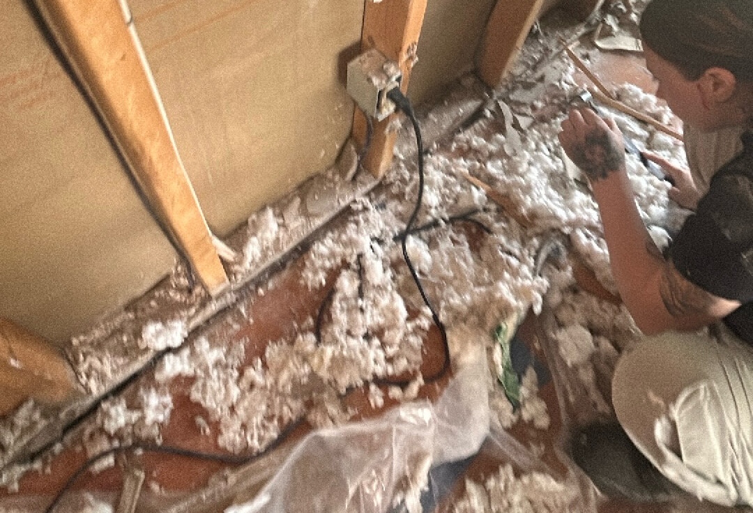 Employee crouched over floor after demo - materials on the ground 