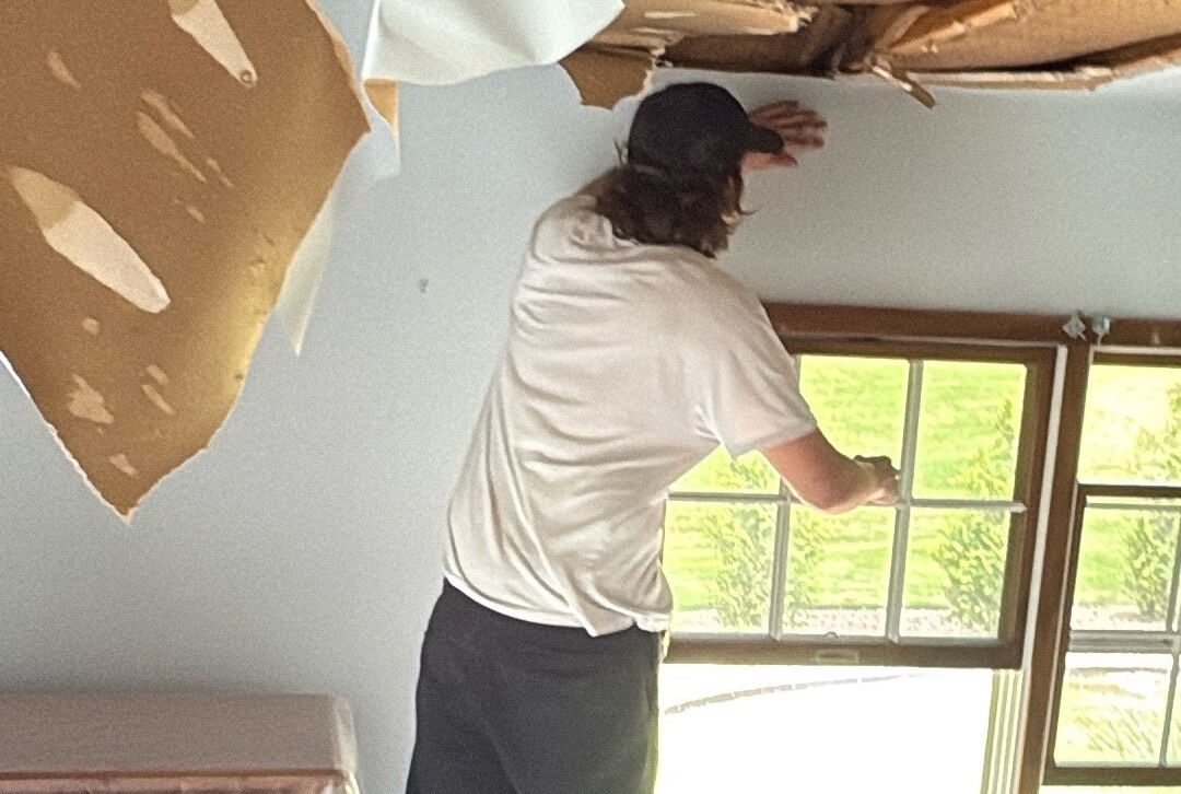Employee on ladder demo to ceiling