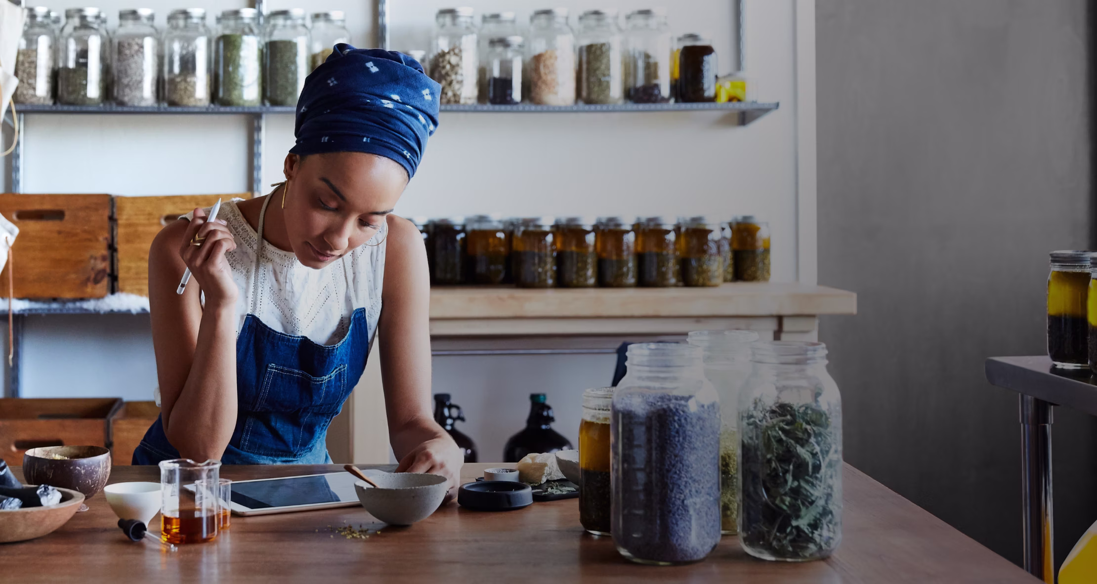Image of a small business owner sitting at a desk and looking at a tablet