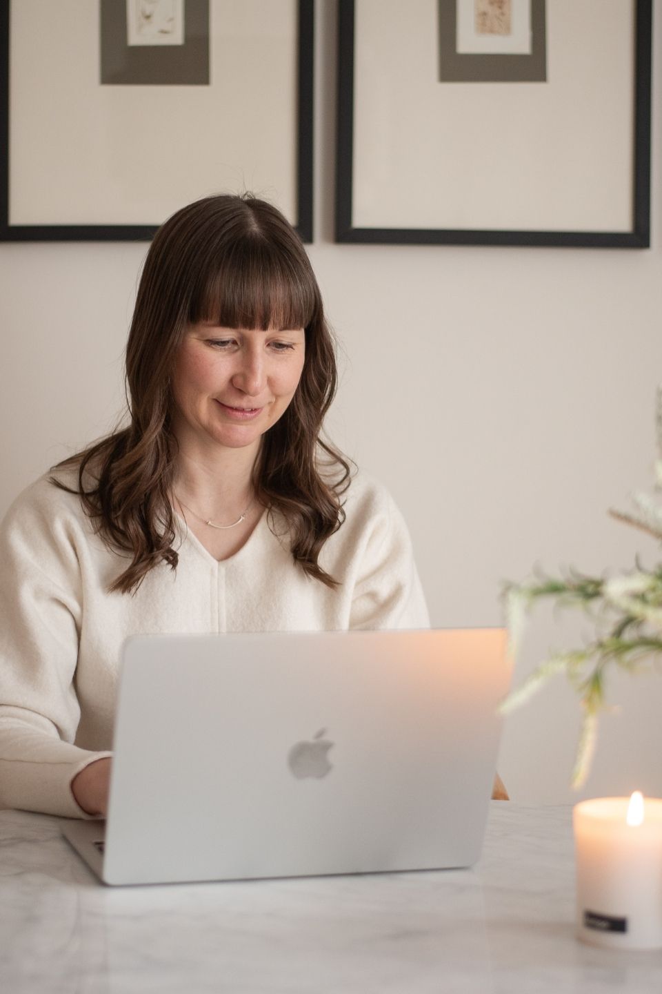 Megan Cook looking at a laptop and smiling.