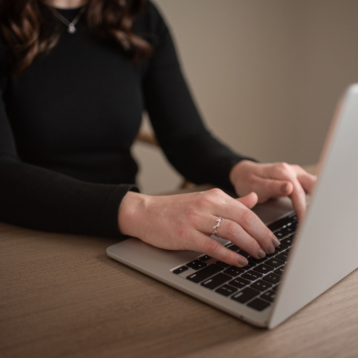 Megan Cook types on a laptop while sitting at a desk.
