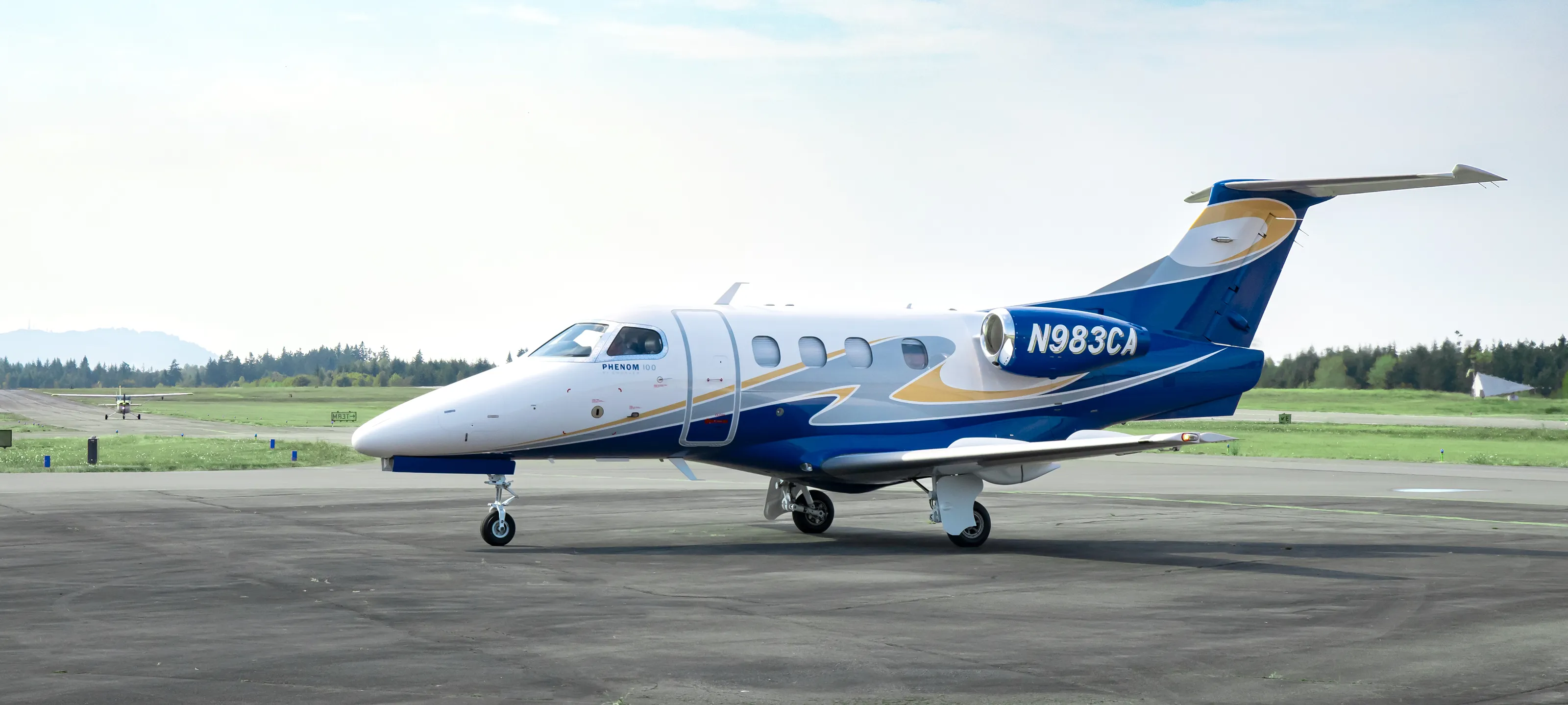 2009 Embraer Phenom 100 N983CA side view on tarmac