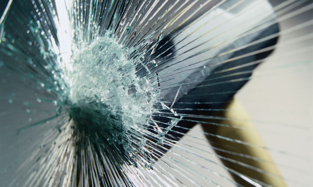 Hitting a hammer against laminated glass.
