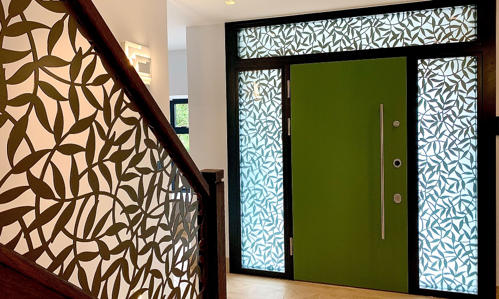 A front door with leave-patterned glazing.