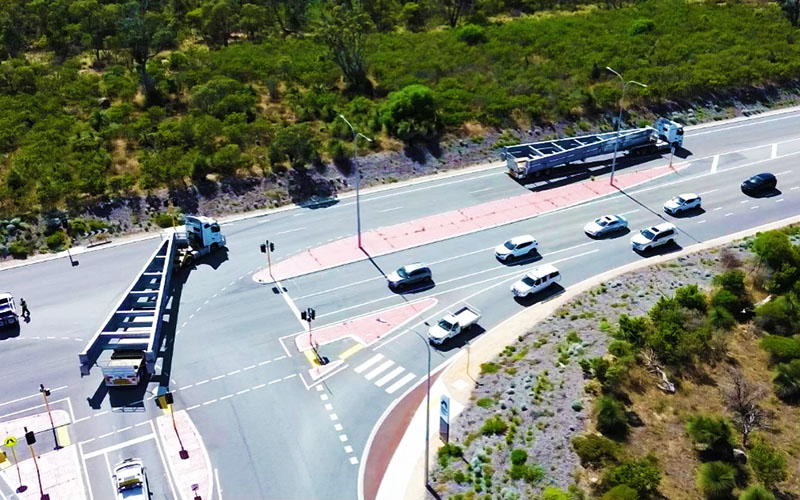 Truck carrying a long load on a multi-lane road, seen from above