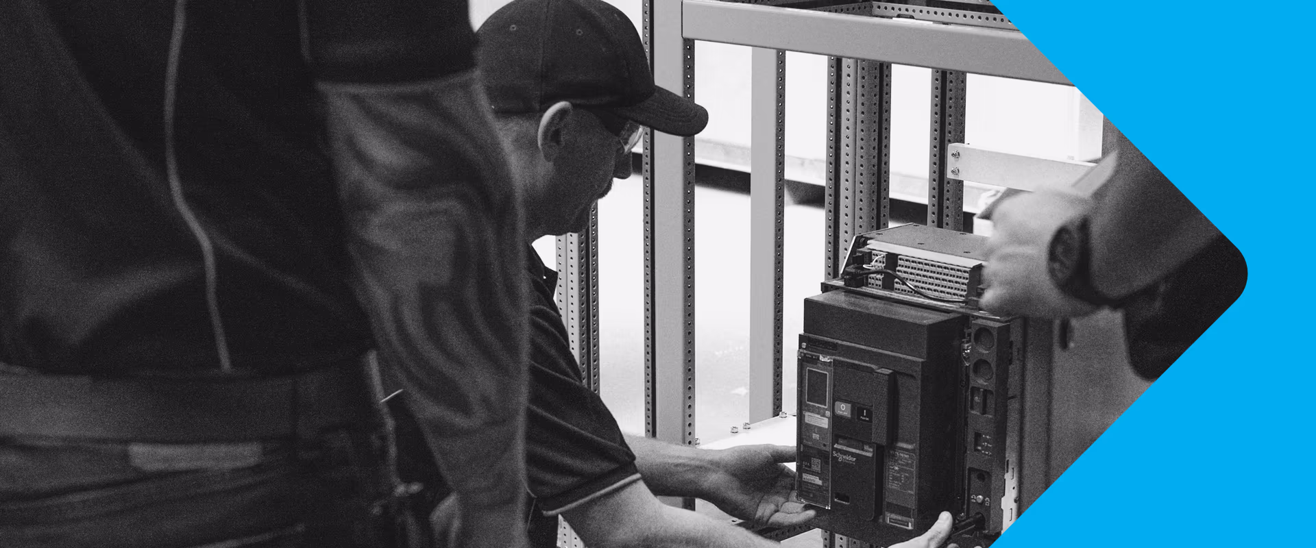 Technician in a cap fitting a circuit breaker into a switchboard