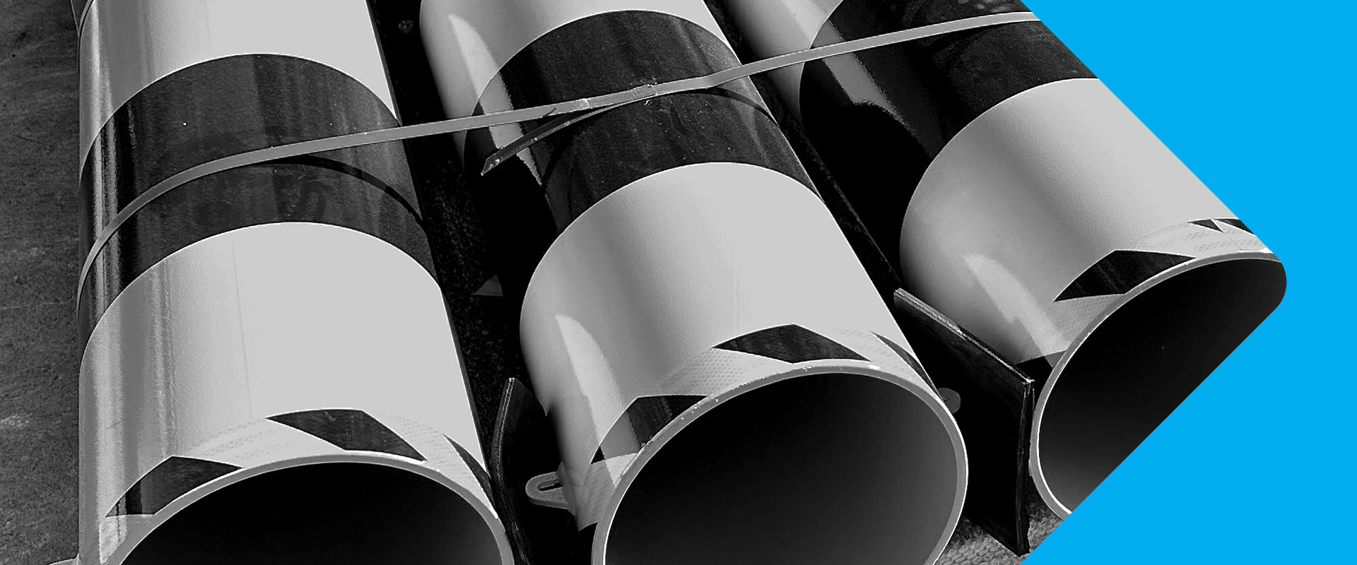 Several large pipes stacked side by side, in black and white