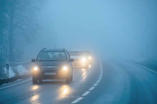 Mehrere Autos, die bei schlechtem Wetter (Nebel, Schnee, Nässe) fahren. 