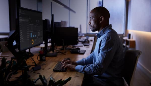 Video forensic analyst reviewing footage on a multi-monitor workstation