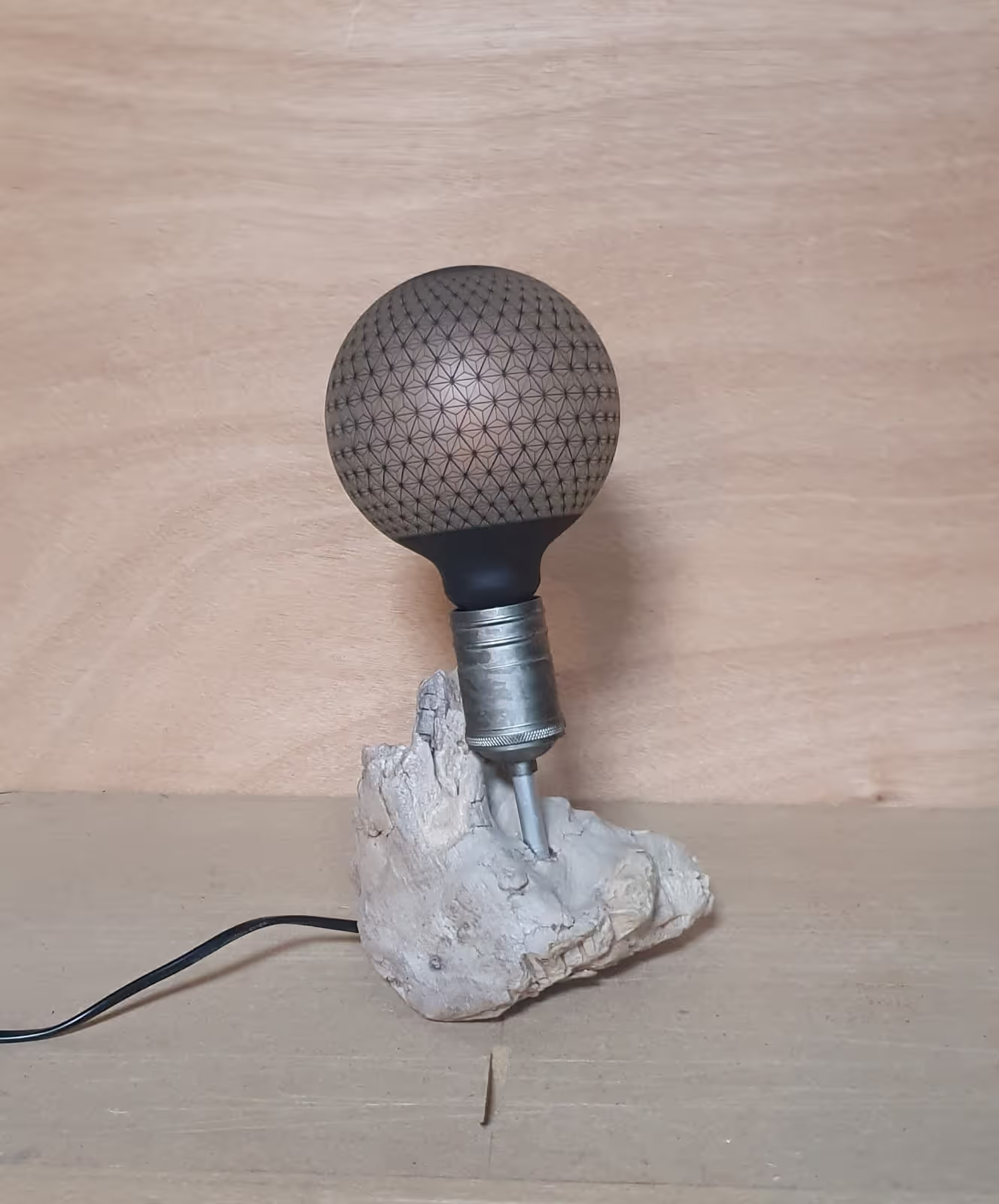 Lampe avec un pied en petite souche de bois flotté et une ampoule de style 'graphite'.
