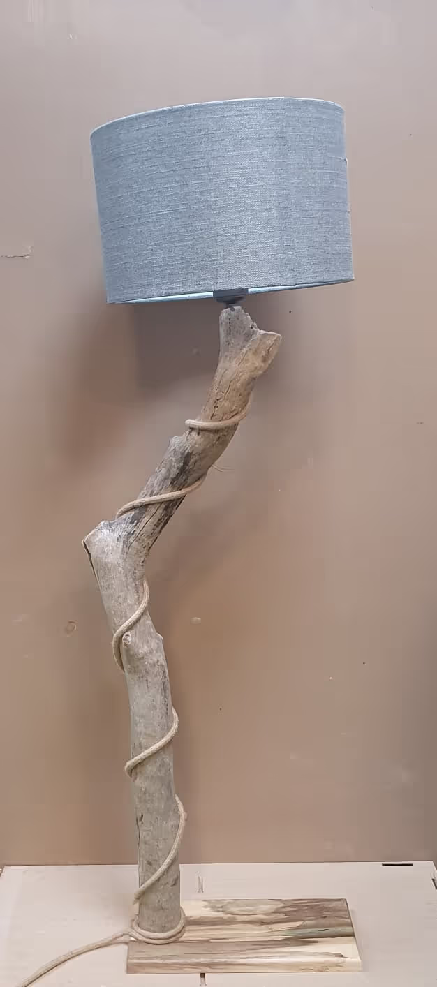 Lampe avec un pied en branche de bois flotté, abat-jour gris moyen et cordon en lin.