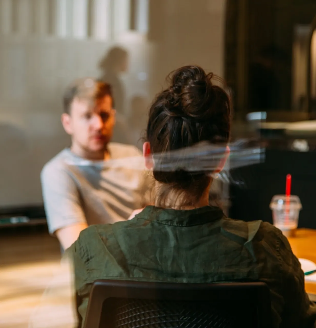 Un homme et une femme assis à une table devant un écran de projection