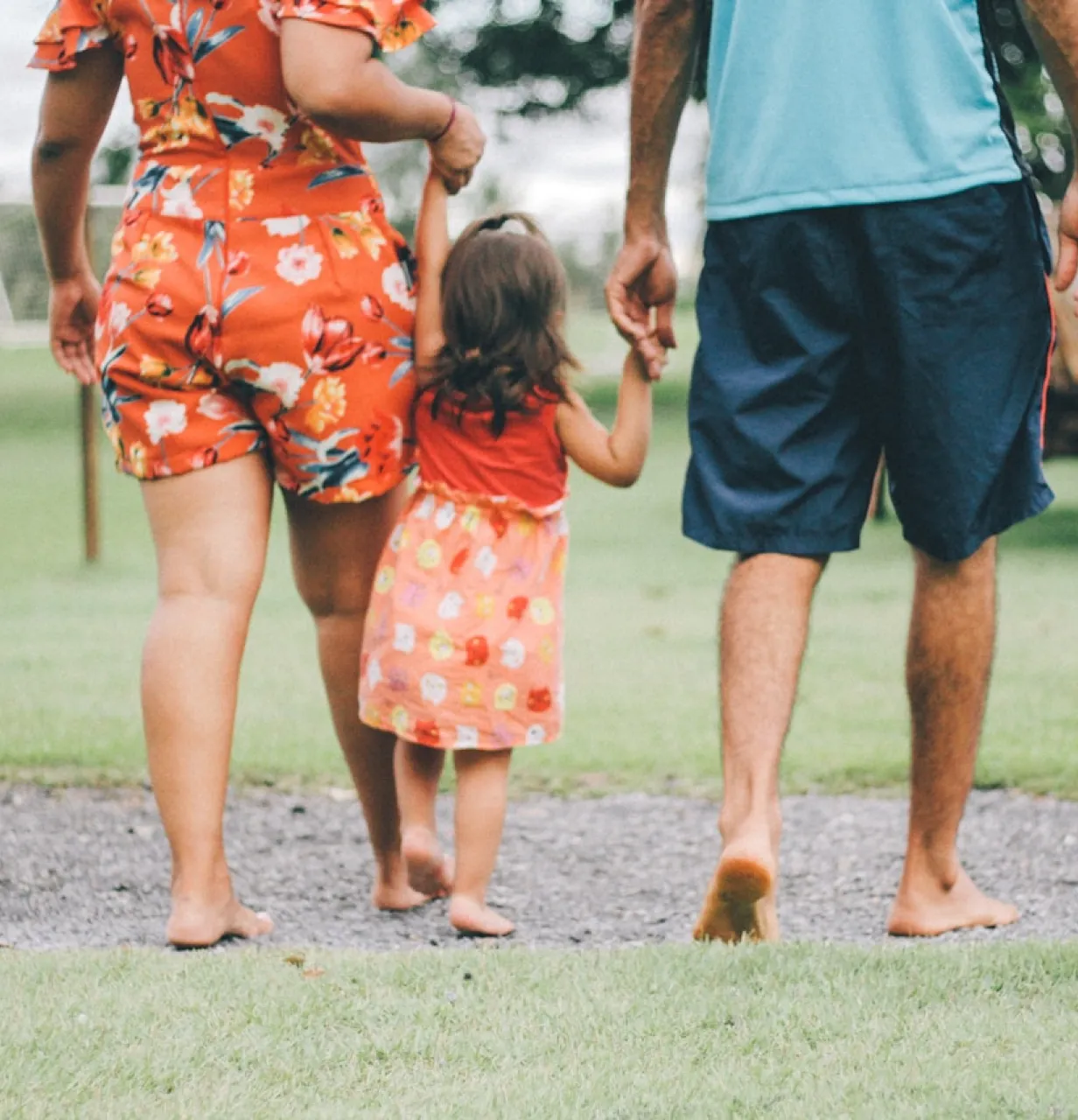 Un homme et une femme se tenant par la main et marchant avec une petite fille