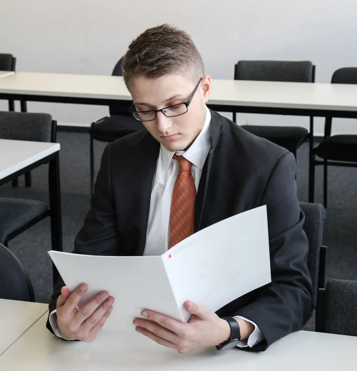 Un homme assis à une table lisant un papier