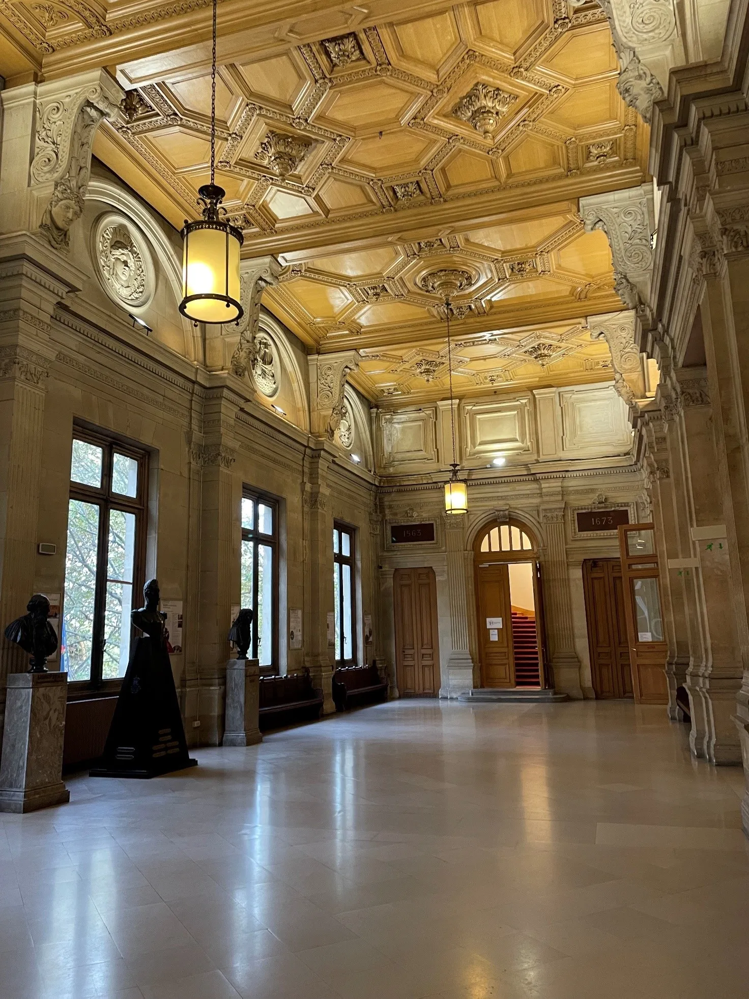 Long couloir en marbre avec des luminaires au plafond