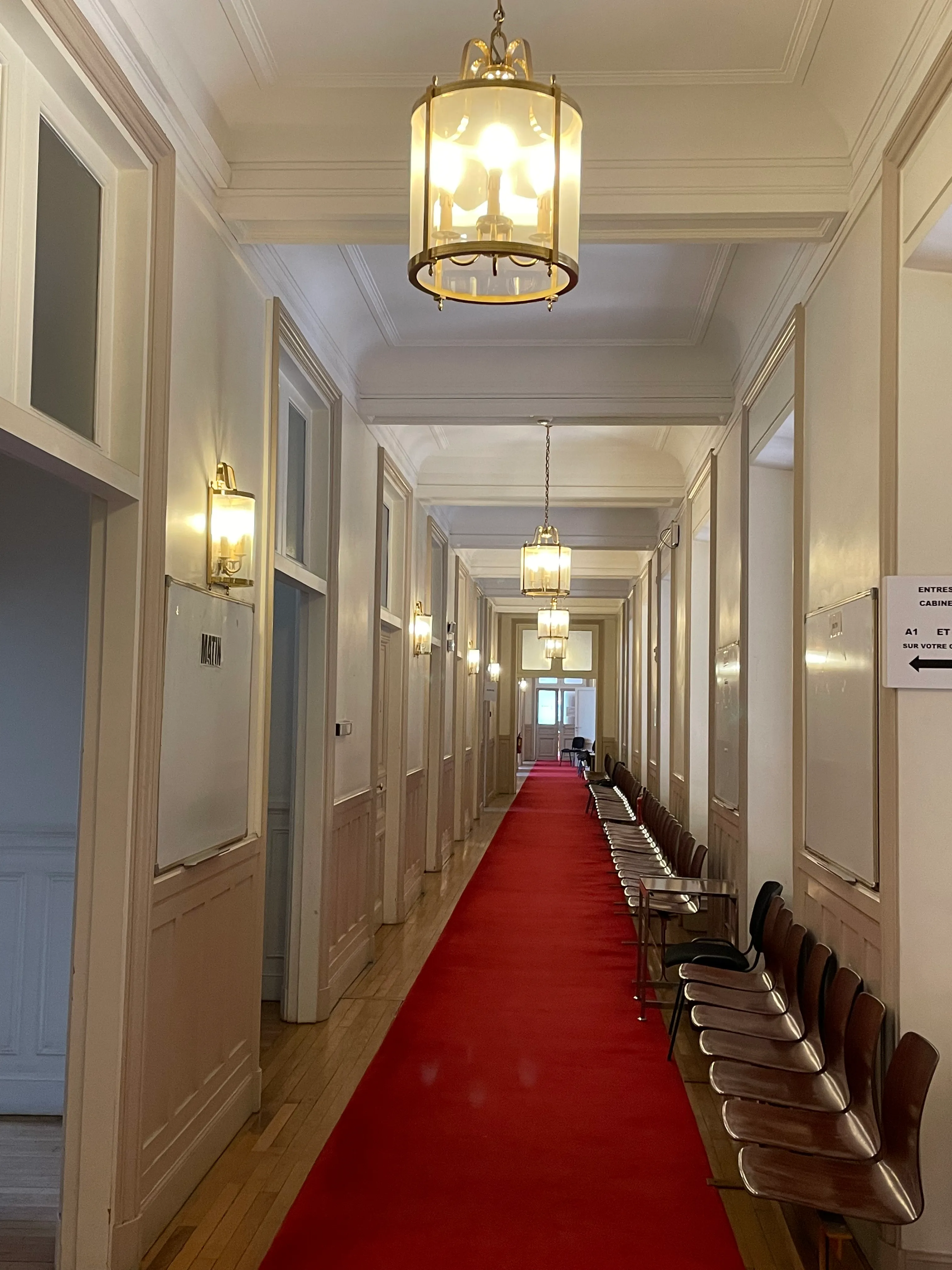 un long couloir avec des colonnes et un tapis rouge