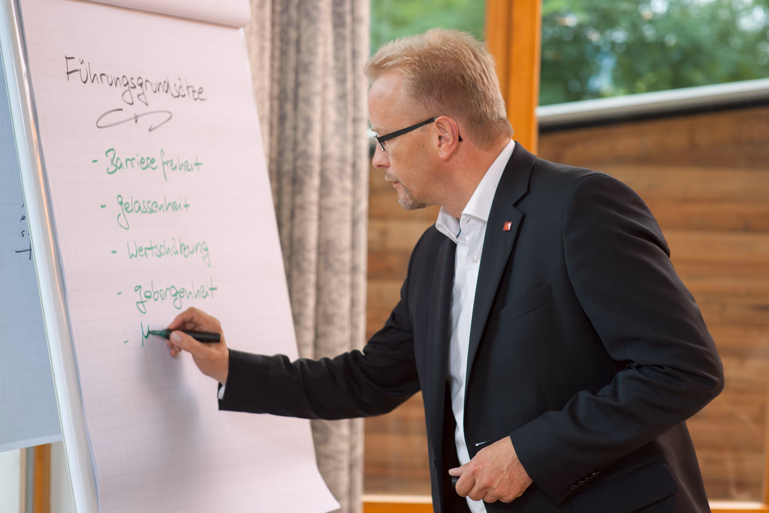 Martin Bünk schreibt an ein Flipchart die Grundsätze der Führung